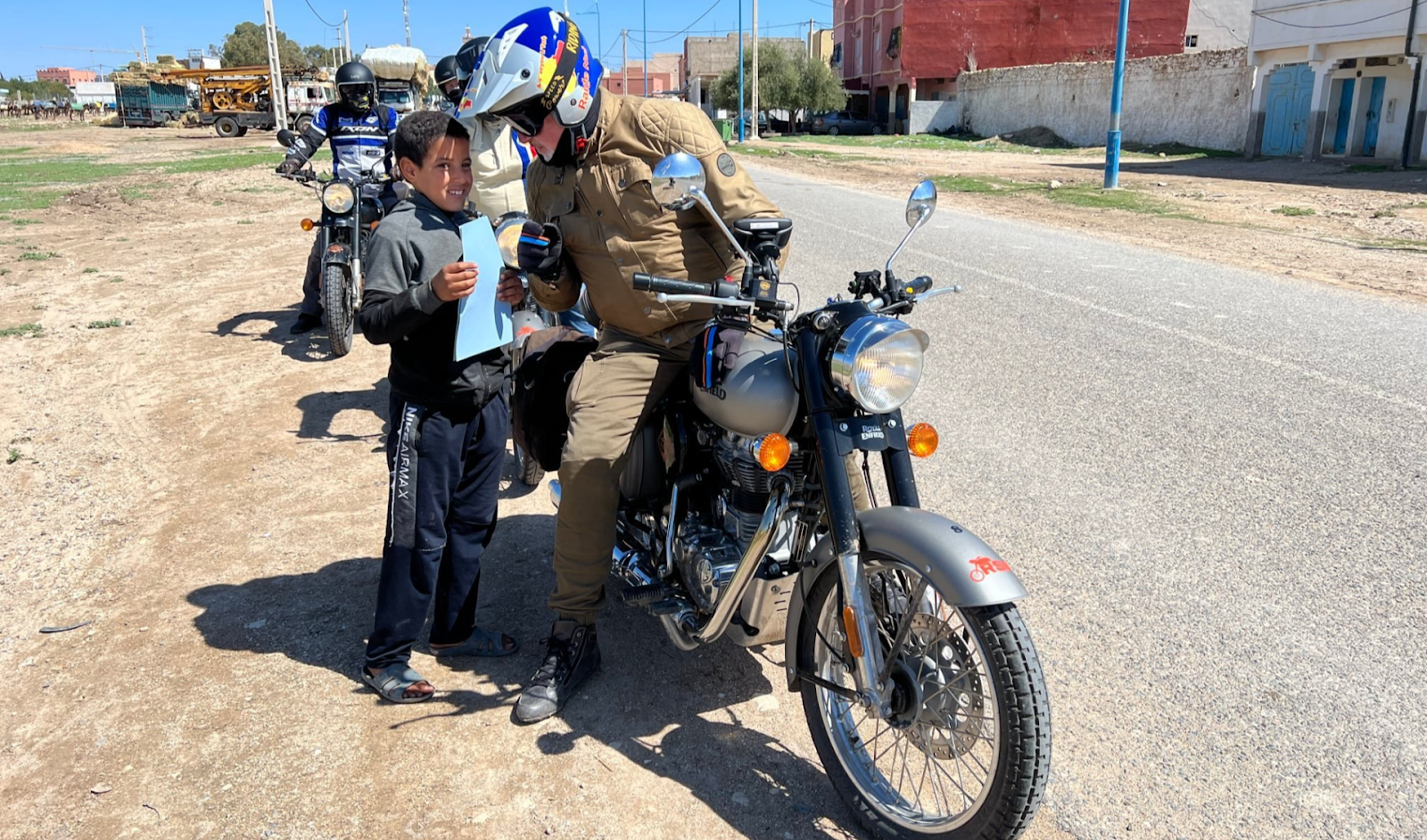 Road trip moto Maroc avec France Moto Voyages : Royal Enfield dans le désert d'Agafay, montagnes de l'Atlas en arrière-plan – Circuit Terre d'Étoiles